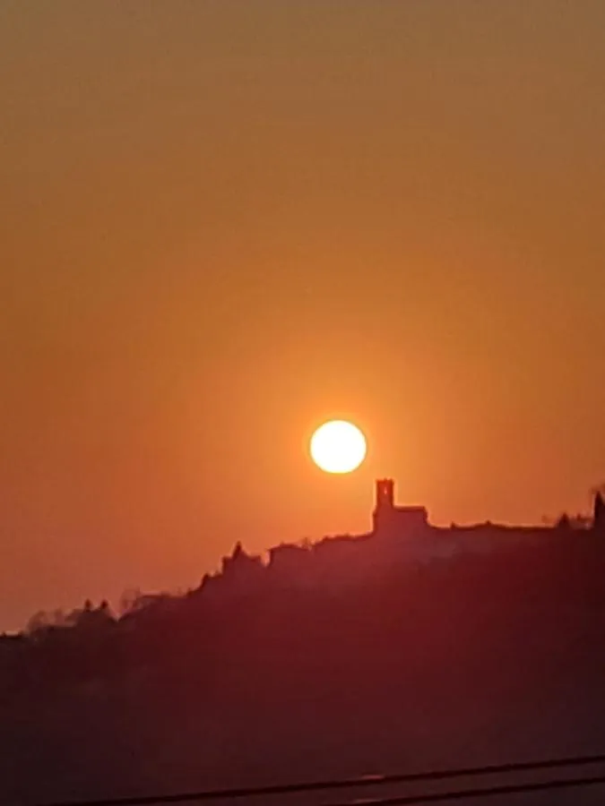 Sonce zahaja za grajskim stolpom